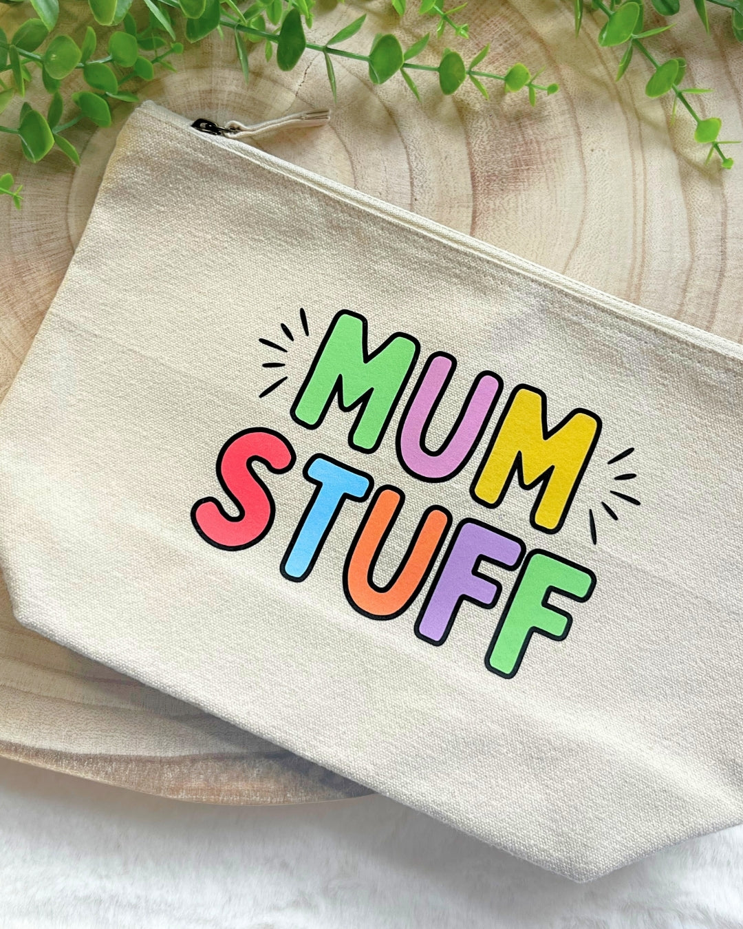 Close-up of a “Mum Stuff” pouch showing bold rainbow letters and sturdy canvas fabric with zip closure.