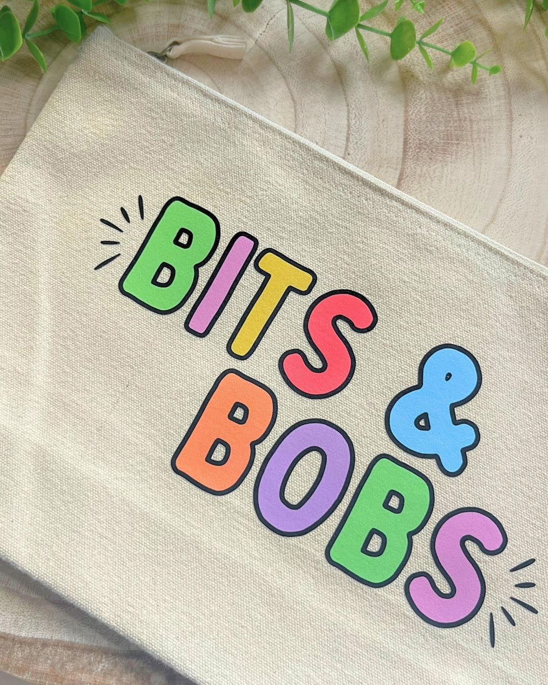 Durable canvas pouch with colorful lettering, ideal for organizing small items like pens, makeup, or keys.