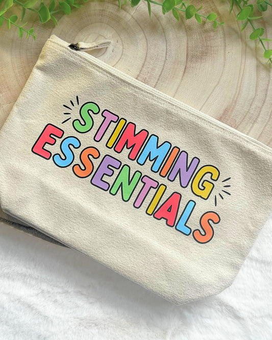 Durable beige zipper bag with rainbow text “Stimming Essentials,” perfect for makeup, stationery, and travel items.
