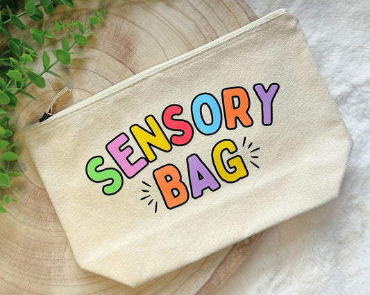 Canvas zip pouch with rainbow text “Sensory Bag,” designed for storing fidgets and sensory tools.